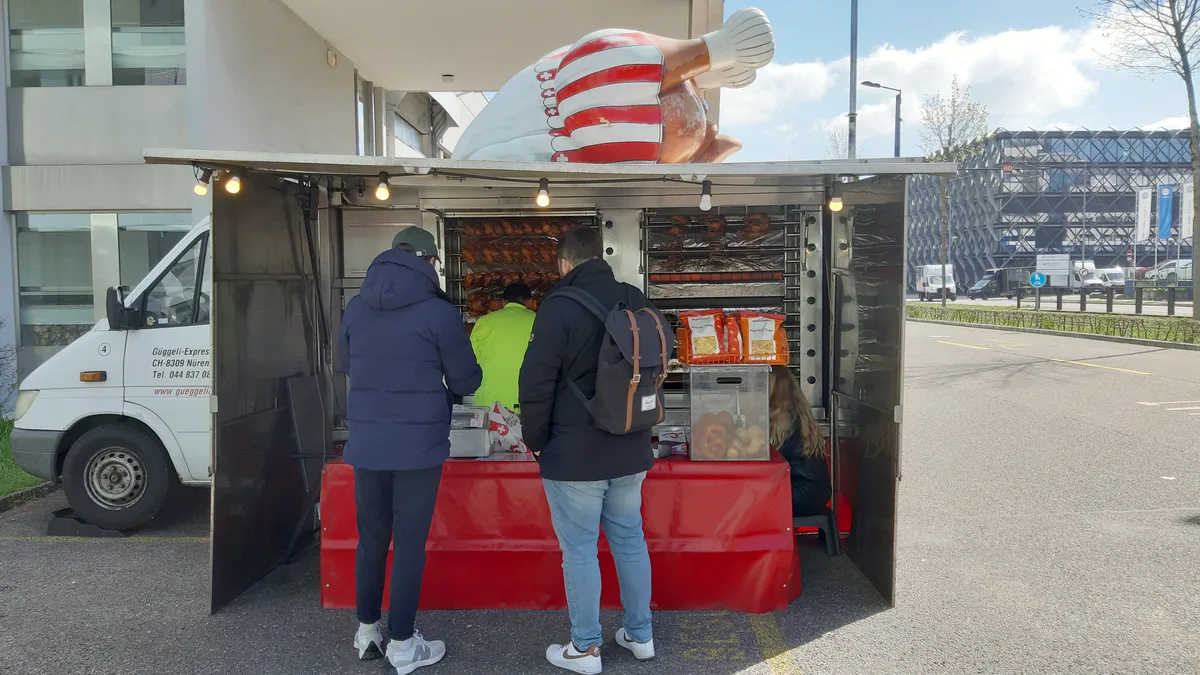 Zwei Männer stehen vor einem Foodtruck.